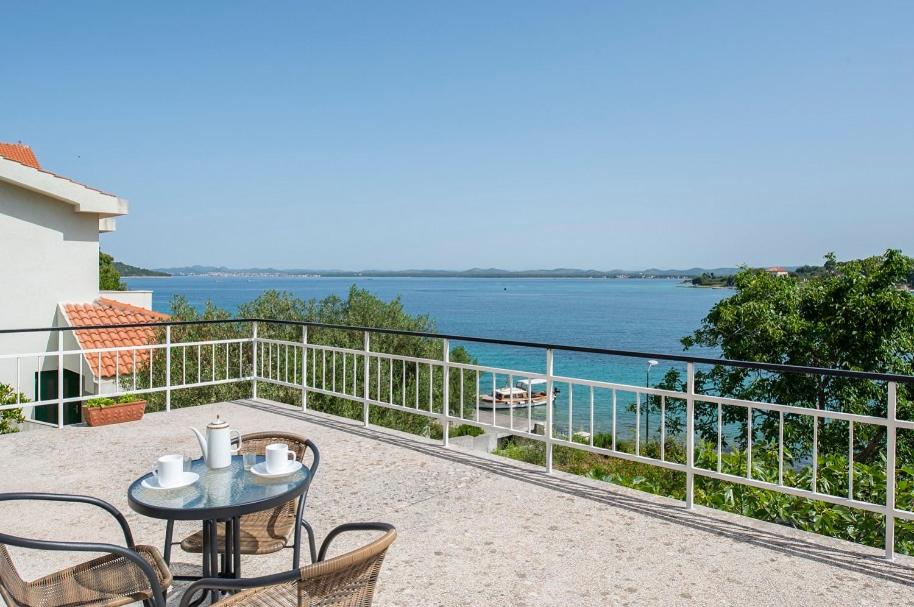 a balcony with a table and chairs and a view of the water at Put Marin in Zlarin