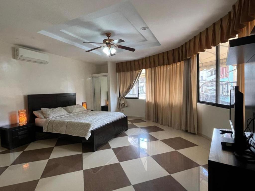 um quarto com uma cama e uma ventoinha de tecto em Aparta Hotel Roma em Santo Domingo