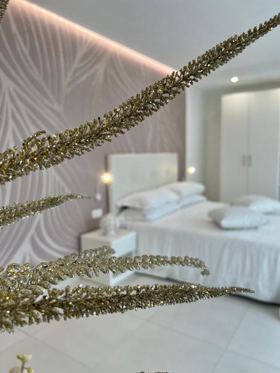 una camera bianca con 2 letti e uno specchio di Sirena Suite Deluxe a Peschici