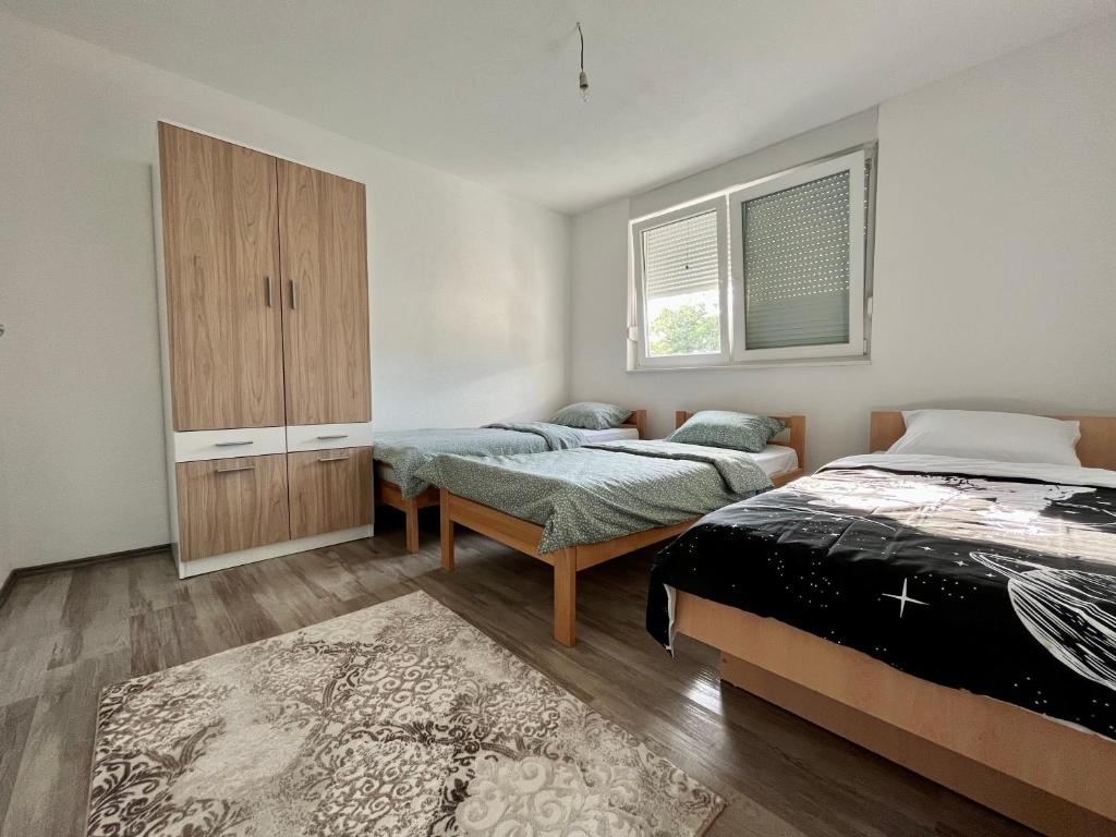 1 Schlafzimmer mit 2 Betten, einem Schrank und einem Teppich in der Unterkunft Apartment Nest Stolac in Stolac