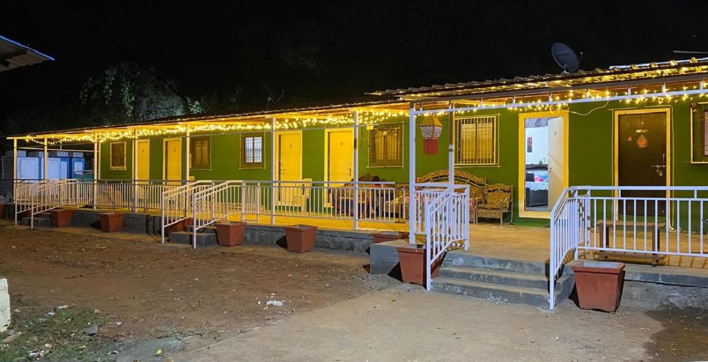 a green and yellow house with lights on it at Green Fog Guesthouse in Lonavala