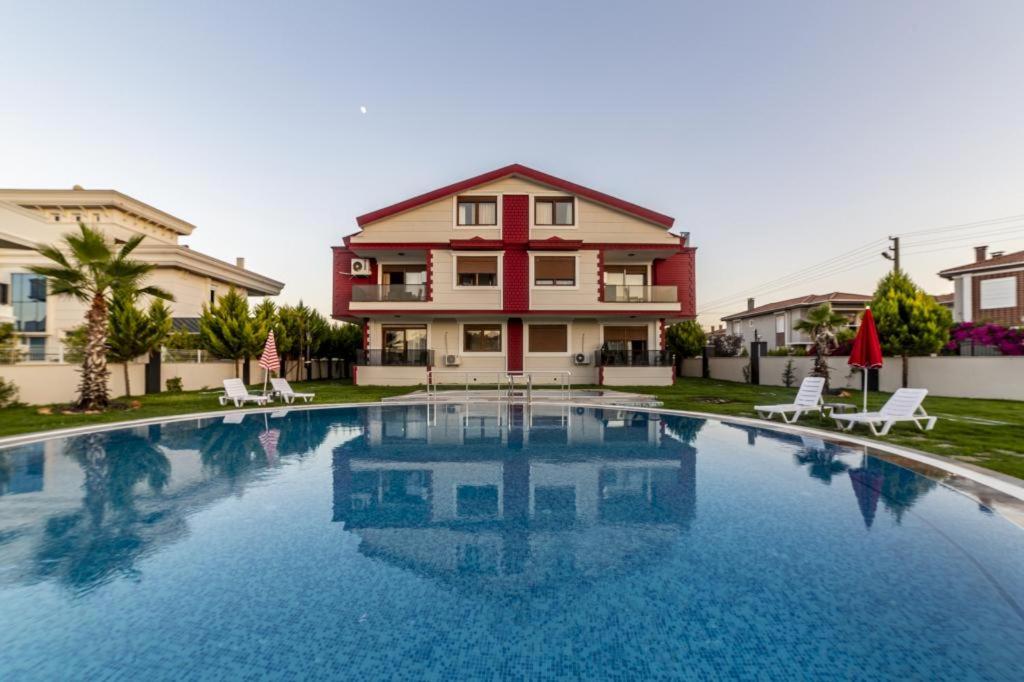 a large swimming pool in front of a house at The Logo Family Apart in Altınkum