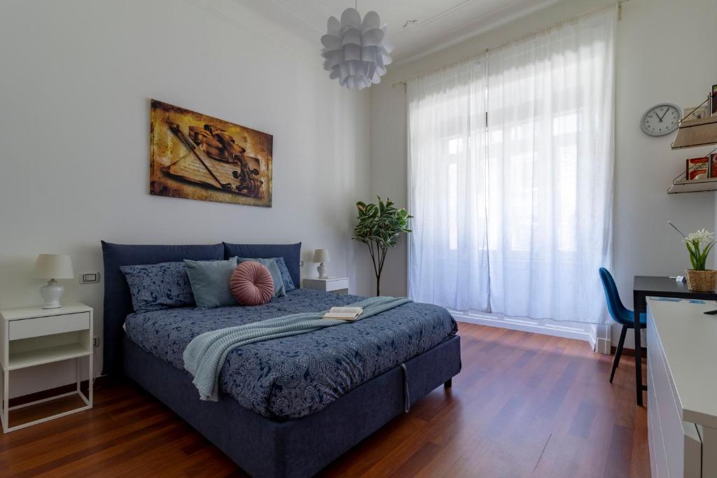 een slaapkamer met een blauw bed en een raam bij Stradivarius House - Carozzi Apartments in Milaan