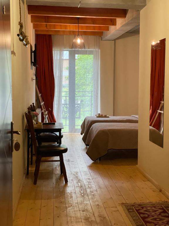 een slaapkamer met een bed, een tafel en een raam bij Hotel Ailama Mestia in Mestia