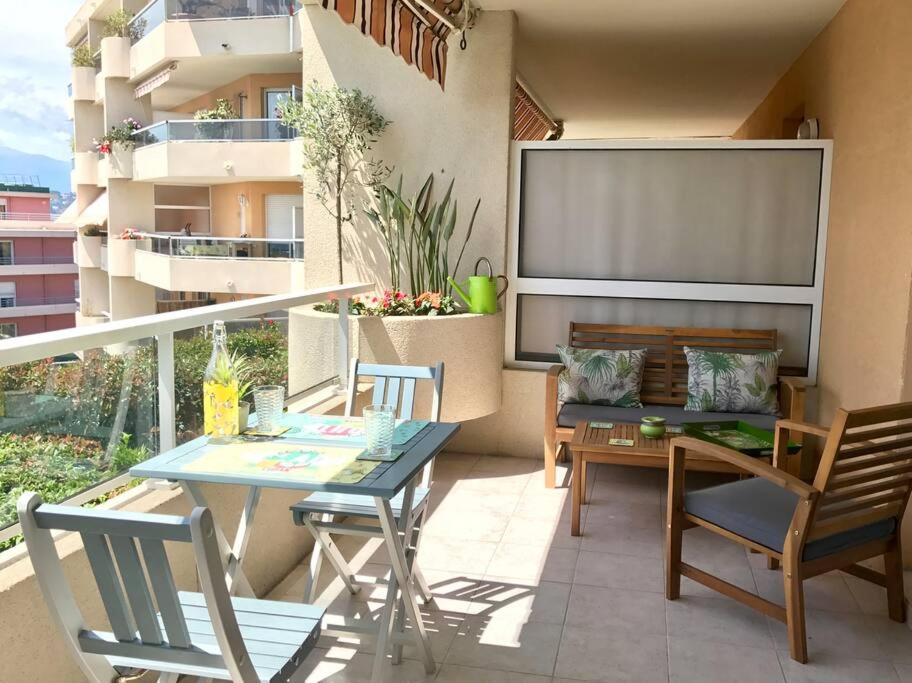 un patio avec une table et des chaises sur un balcon dans l'établissement Nice ouest- Studio Vue Mer Garage Piscine WIFI, à Nice
