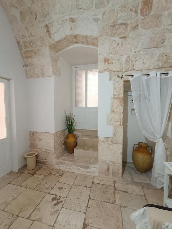 a large bathroom with a stone wall and a shower at Casetta Wetto' in Monopoli