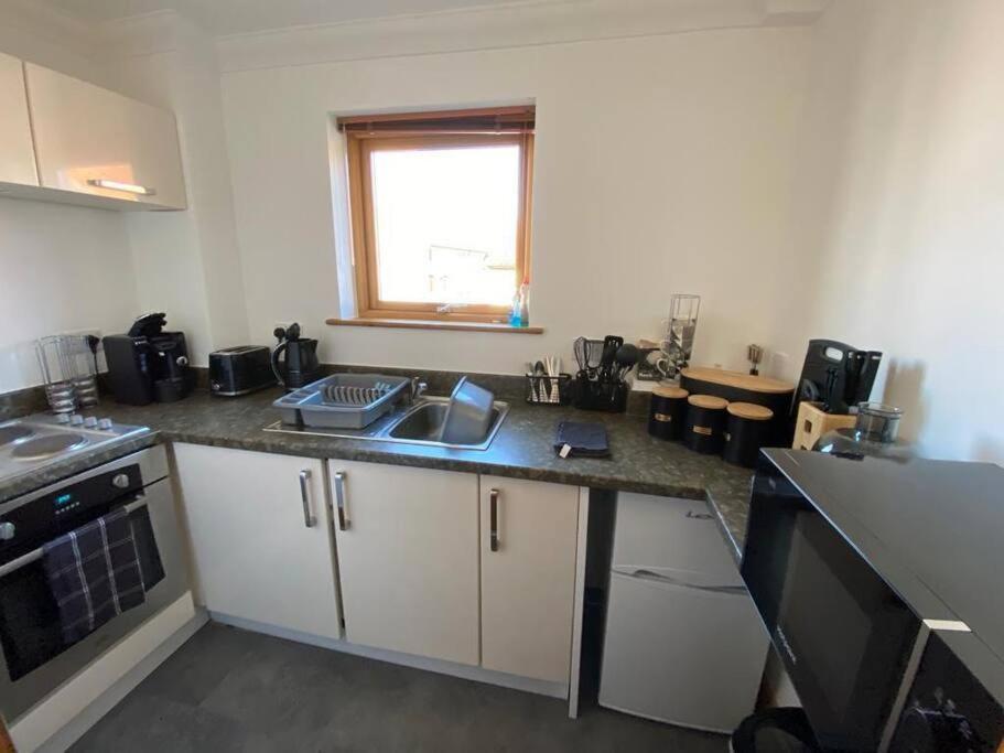 een keuken met een wastafel en een aanrecht bij Lovely studio apartment in Norwich city centre in Norwich