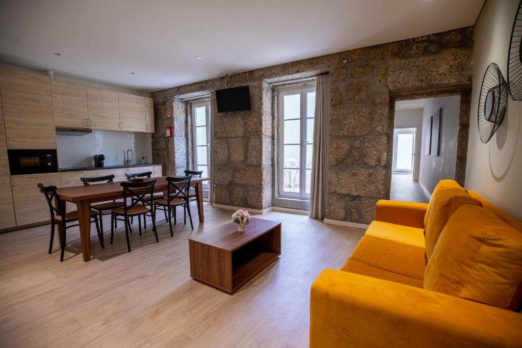 ein Wohnzimmer mit einem gelben Sofa und einem Tisch in der Unterkunft HAGAH Alojamentos in Guimarães