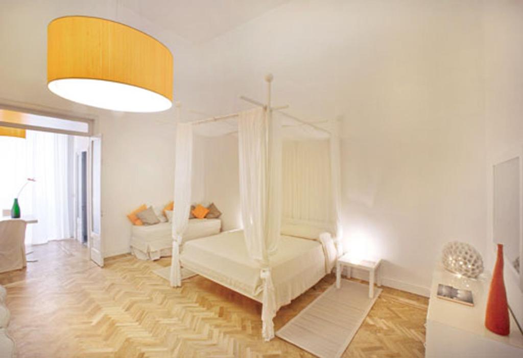 een witte kamer met een bed en een bank bij Malìa bed and breakfast in Lecce
