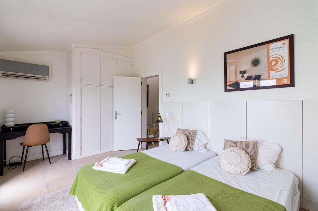 1 dormitorio con cama verde y escritorio en BmyGuest - Vilamoura Marina's View, en Vilamoura