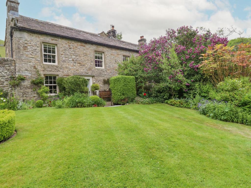 an old stone house with a large yard at Hilltop House in Starbotton