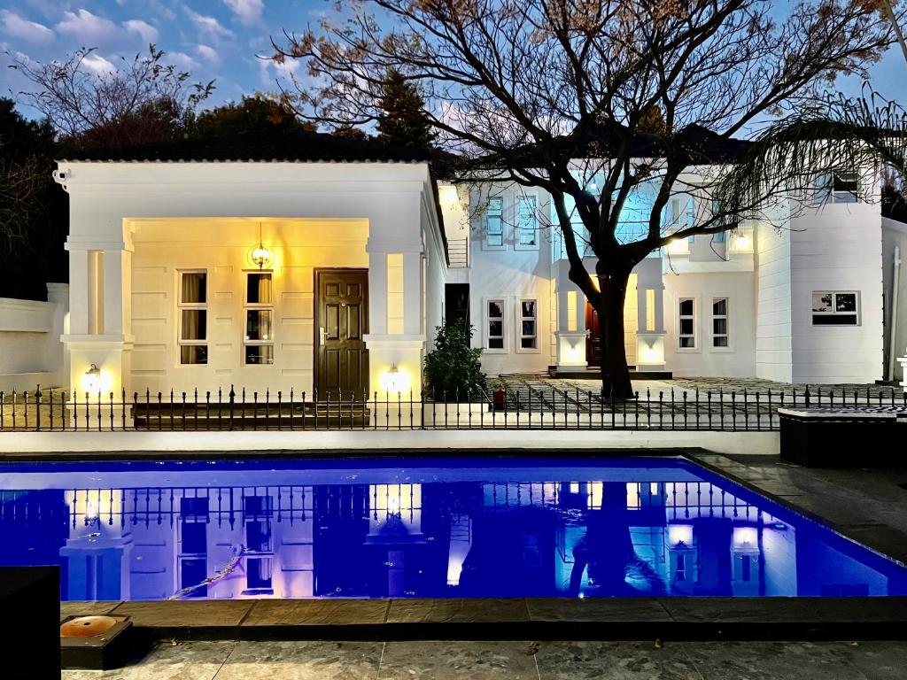 a white house with a pool in front of it at 435 on vale boutique aparthotel in Johannesburg