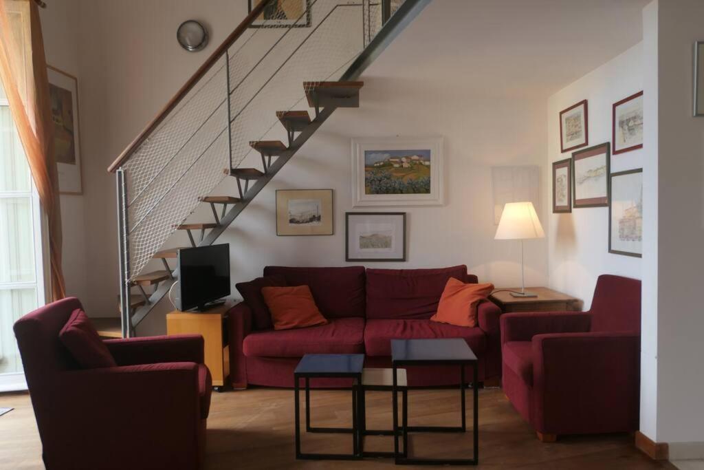 een woonkamer met een rode bank en een trap bij Loft Bellevue - Seaview - WiFi in Menton