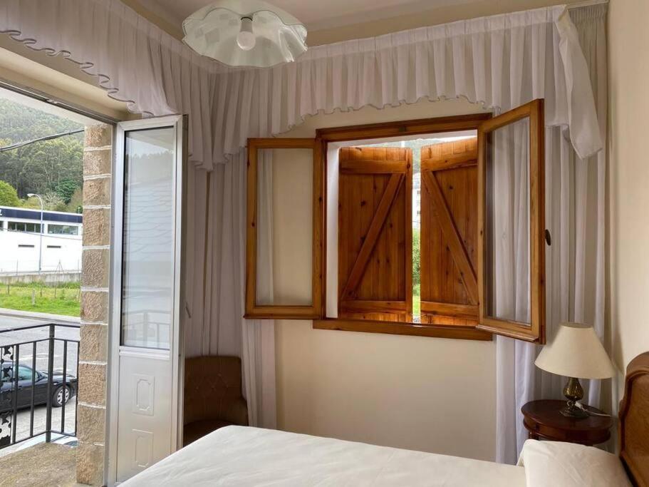 a bedroom with a bed and a window at VIVEIRO.CELEIRO. CASA TRANQUILA. RESURRECTION FEST in Cillero