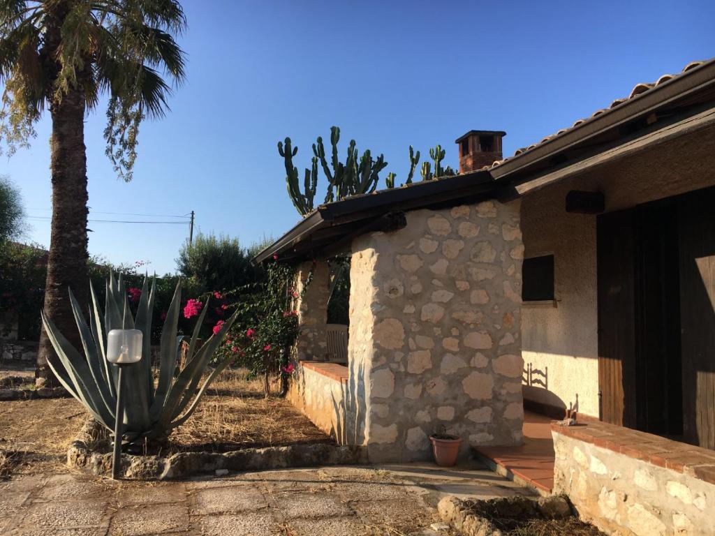 a house with a cactus next to a palm tree at Villa Mara in San Lorenzo