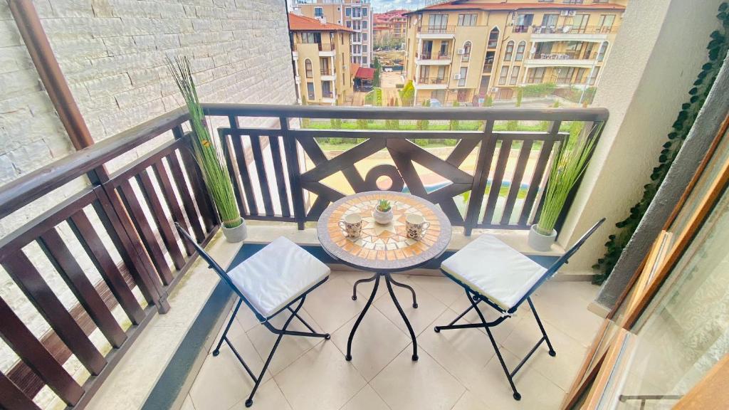a balcony with a table and chairs on a balcony at Bratanov Royal Palm Apartments in Sveti Vlas