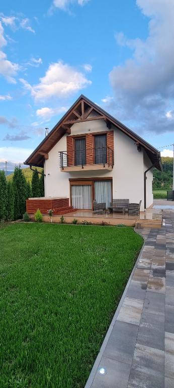 a house with a green lawn in front of it at River home - Villa Sara in Bihać