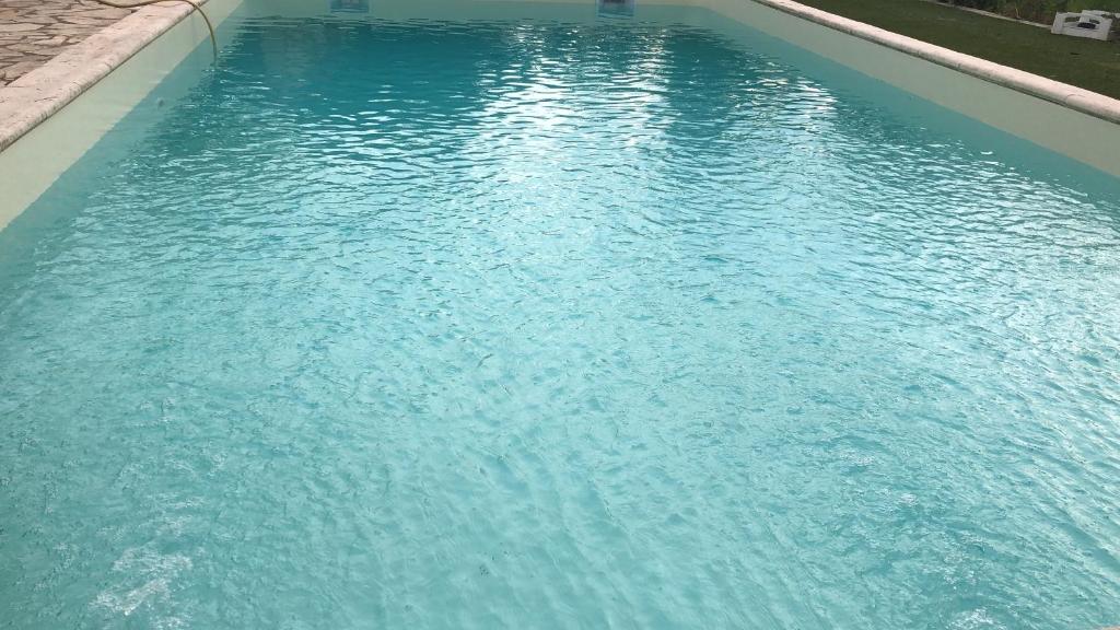 une grande piscine d'eau bleue dans une cour dans l'établissement Chambre pratique avec Wc et vasque attenant du rucher naturaile, à Montagnac