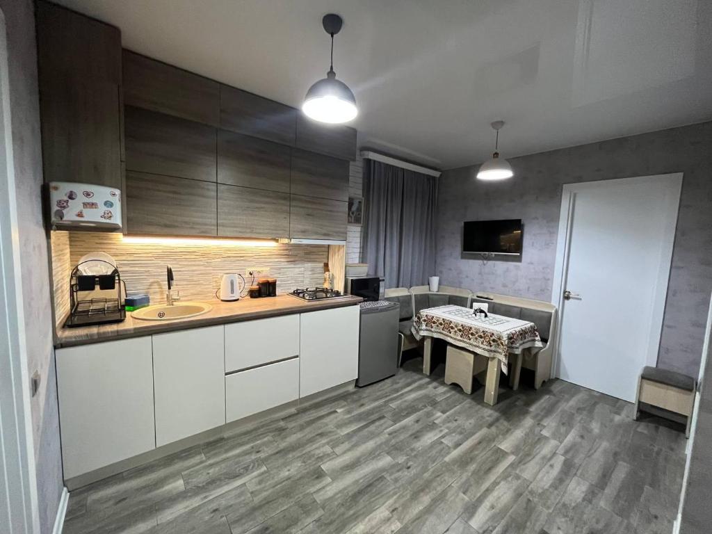 Una cocina con gabinetes blancos y un fregadero y una mesa. en AnNi old Tbilisi apartaments, en Tiflis