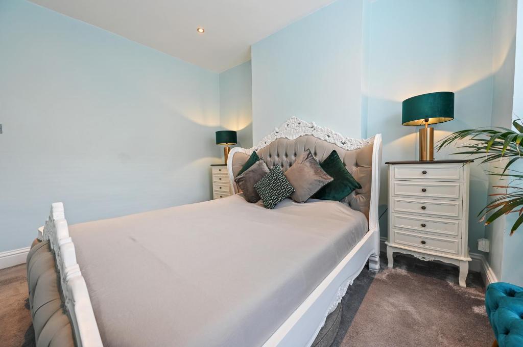 a bedroom with a white bed and a dresser with lamps at Wembley Luxury Residence- Opulence House in London