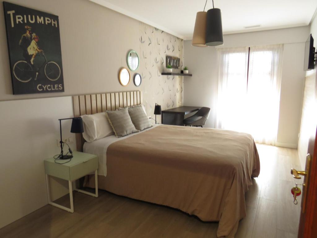 um quarto com uma cama, uma mesa e uma janela em Casa Rural Artola em Astigarraga