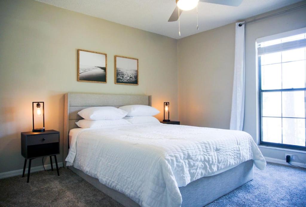 坦帕的住宿－Serene Townhouse near Moffitt, Advent, & USF，卧室配有白色的床和2扇窗户。