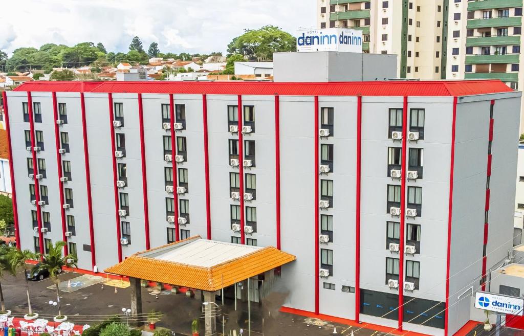 a white building with a red roof at Hotel Dan Inn Araraquara in Araraquara