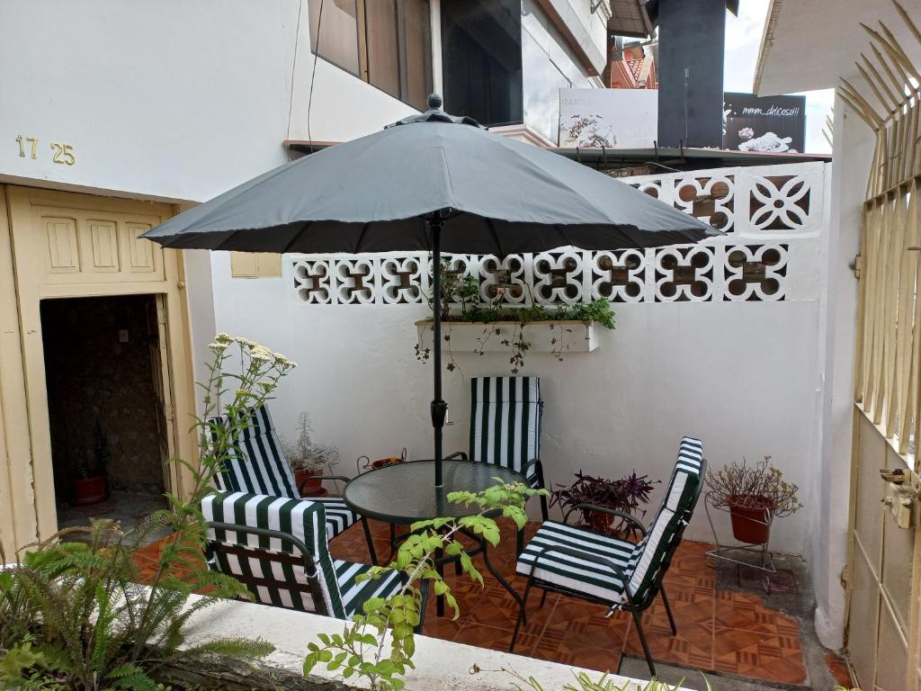 a patio with a table and chairs under an umbrella at Villa Amada a place to relax and take a rest in Loja