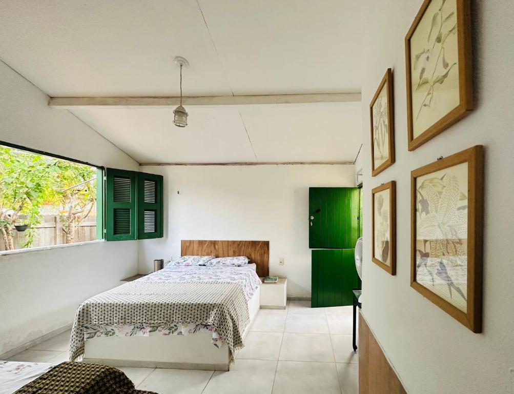 um quarto com uma cama e uma porta verde em Pousada Vila Matury em Icapuí