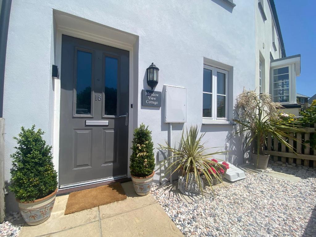 a door of a house with potted plants in front of it at Meadow View in Truro