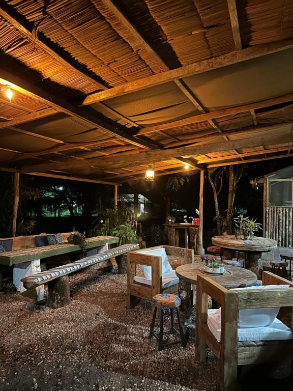 a patio with wooden tables and benches under a roof at Hotel Urumajó in Augusto Correa