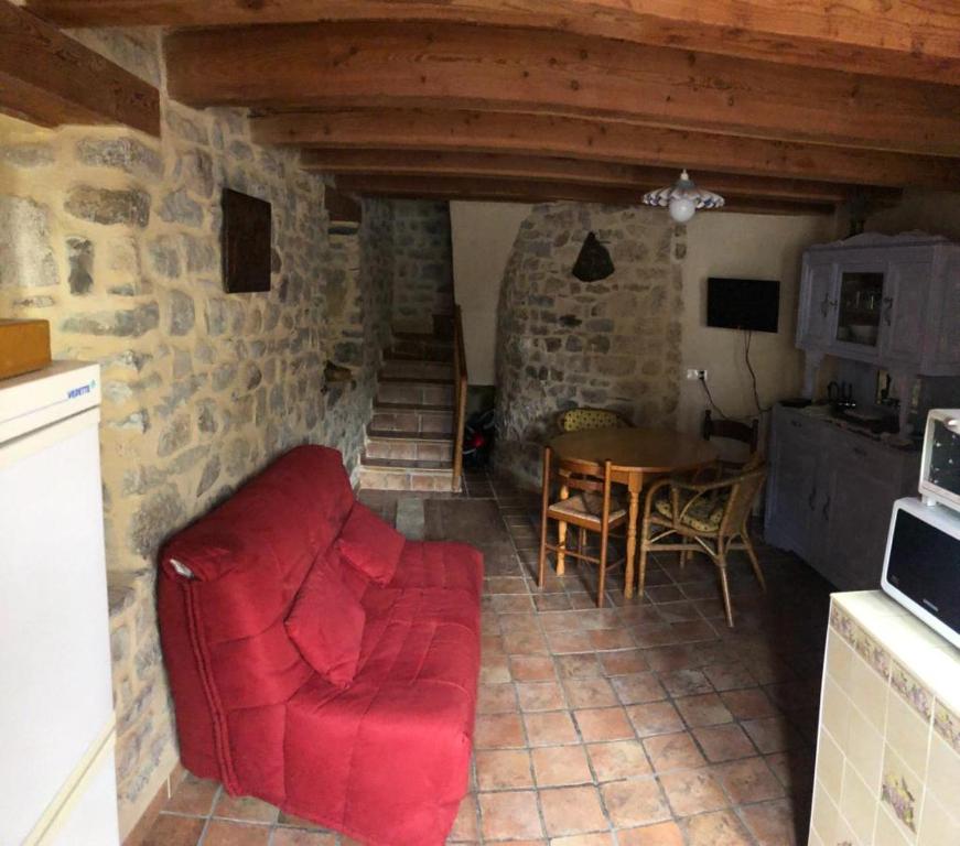 a living room with a red couch and a table at maison vacances in Quézac