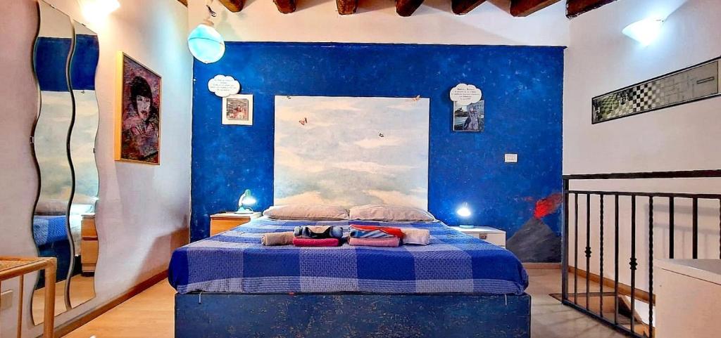 um quarto com uma cama com uma parede azul em Apartment mYourHome em Catânia