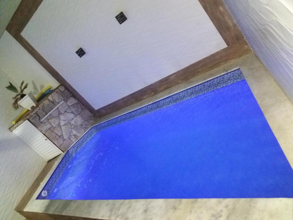 una vista aérea de una piscina azul en una casa en DISPONIVEL NATAL E REVEILLON - Casa Linda e Aconchegante com Piscina -Aquecimento Solar o Ano Todo Perto da Praia, en Praia Grande