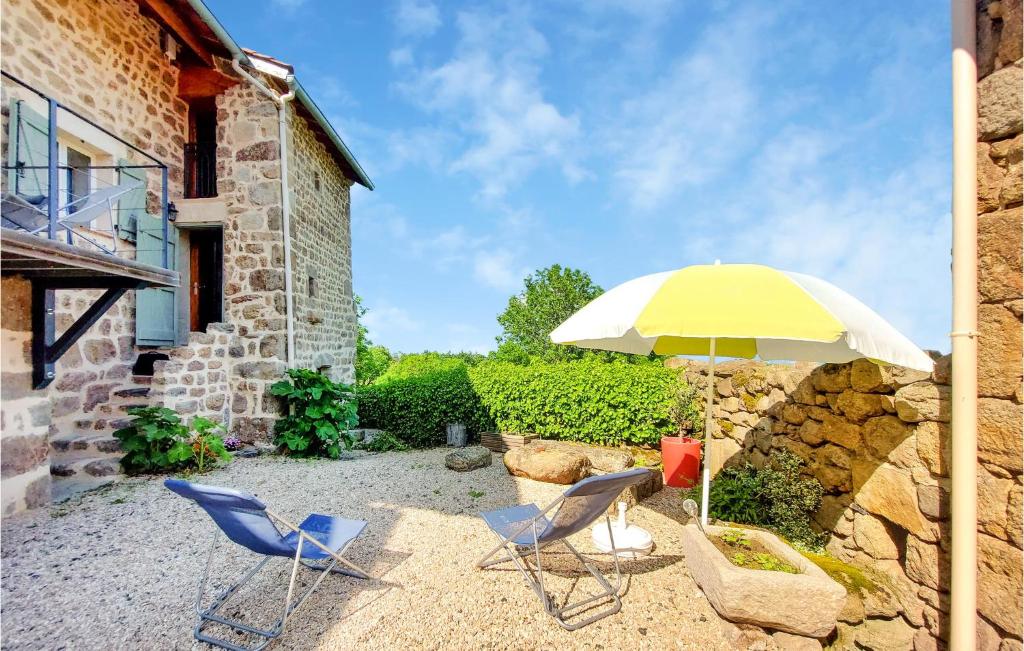 a patio with two chairs and an umbrella at Amazing Home In Essertines-en-chtelne With 3 Bedrooms in Essertines-en-Châtelneuf