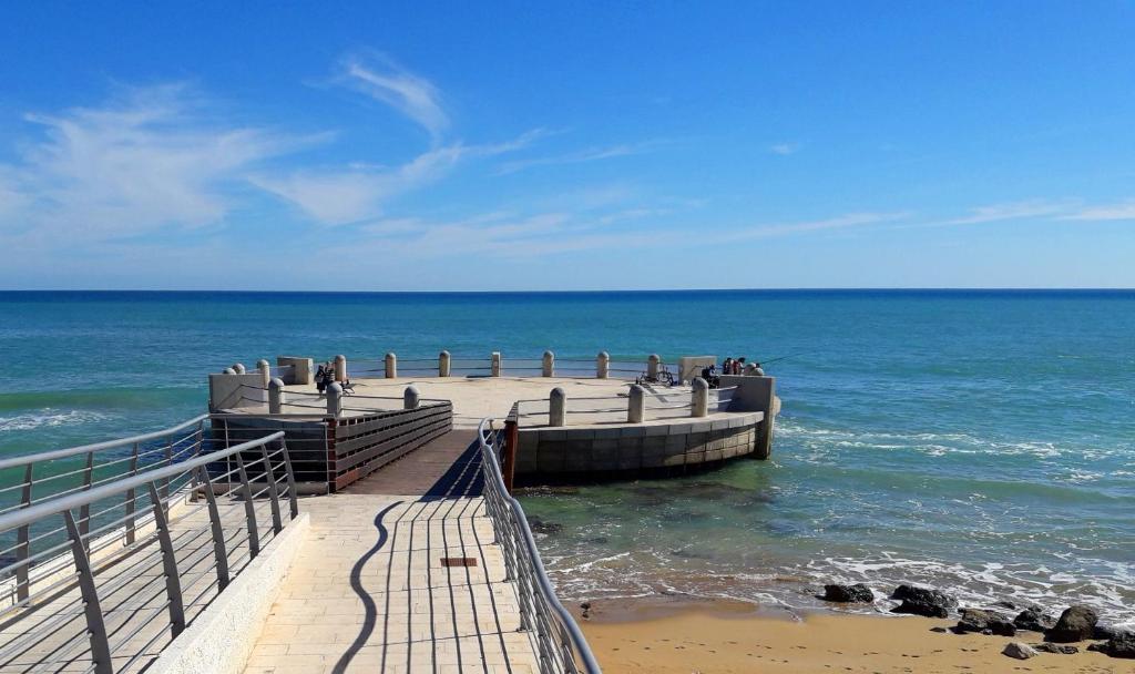 a pier at the ocean with people on it at TONNARA HOUSE AND HOLIDAY in Avola