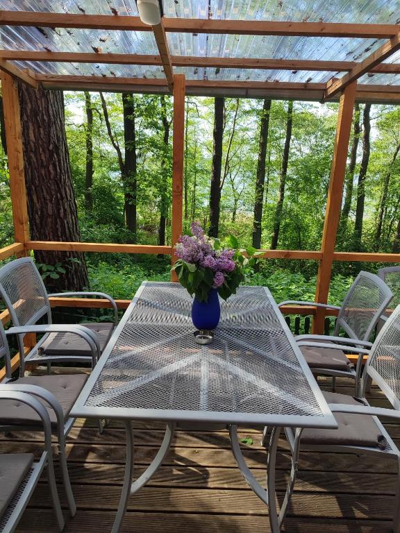 a table with a vase of flowers on a deck at Boszkowo Domki-Stonki in Boszkowo