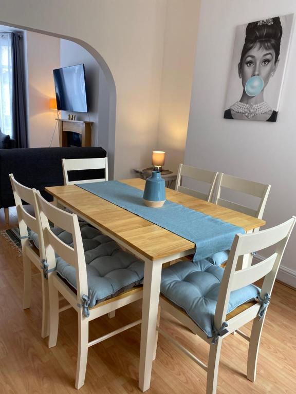 a dining room table and chairs with a blue table cloth at Elizabeth Line Garden home in Ilford