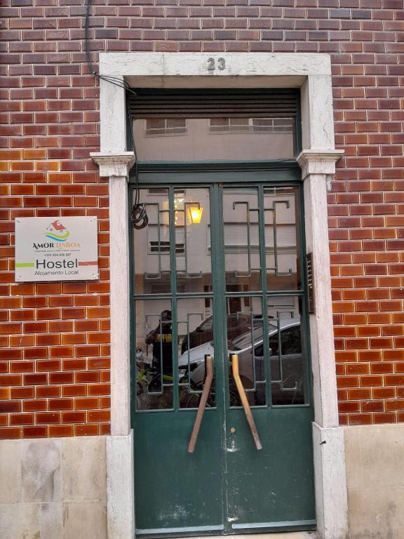 a door in a brick building with two baseball bats at Amor Lisboa Hostel in Lisbon