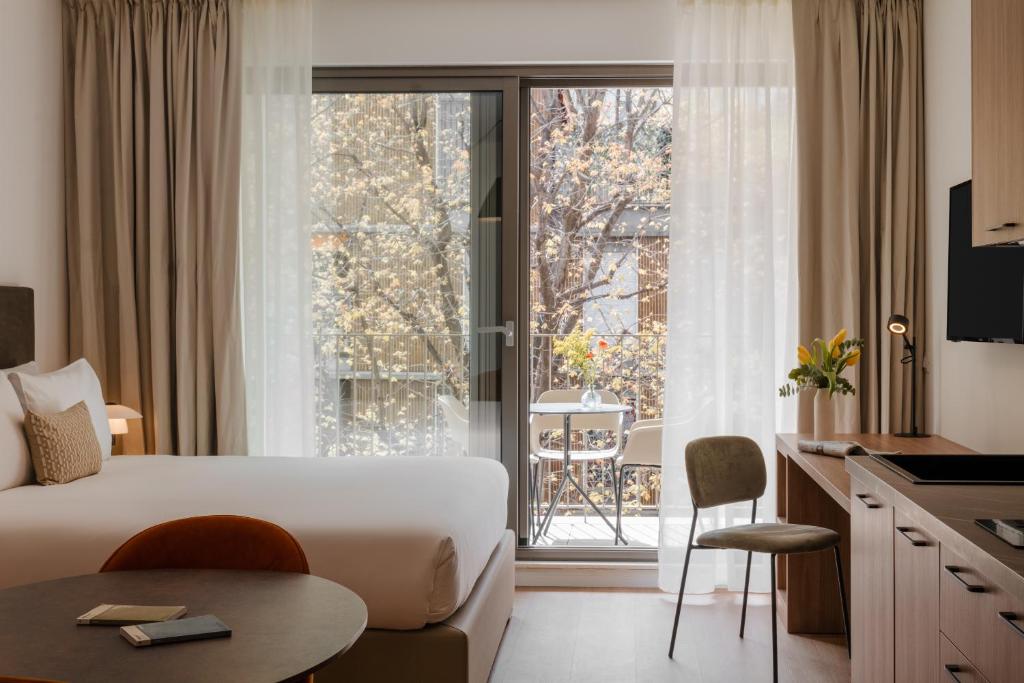 Habitación de hotel con cama y ventana grande en Sonder Atelier, en Milán