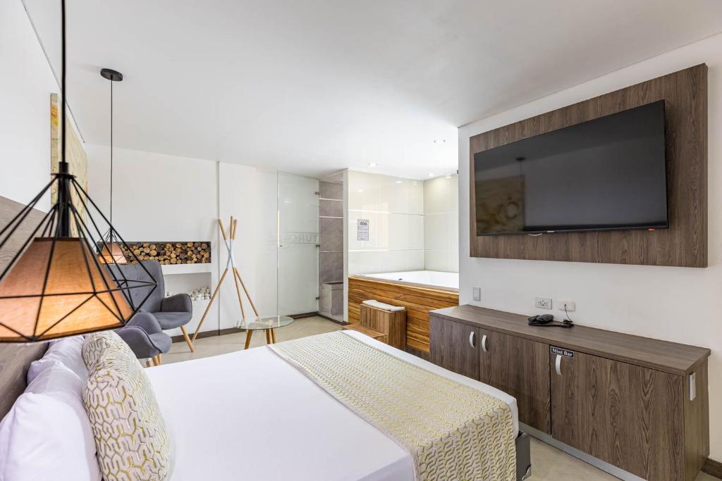 Hotel Velero في San Antonio de Pereira: غرفة نوم بسرير وتلفزيون بشاشة مسطحة