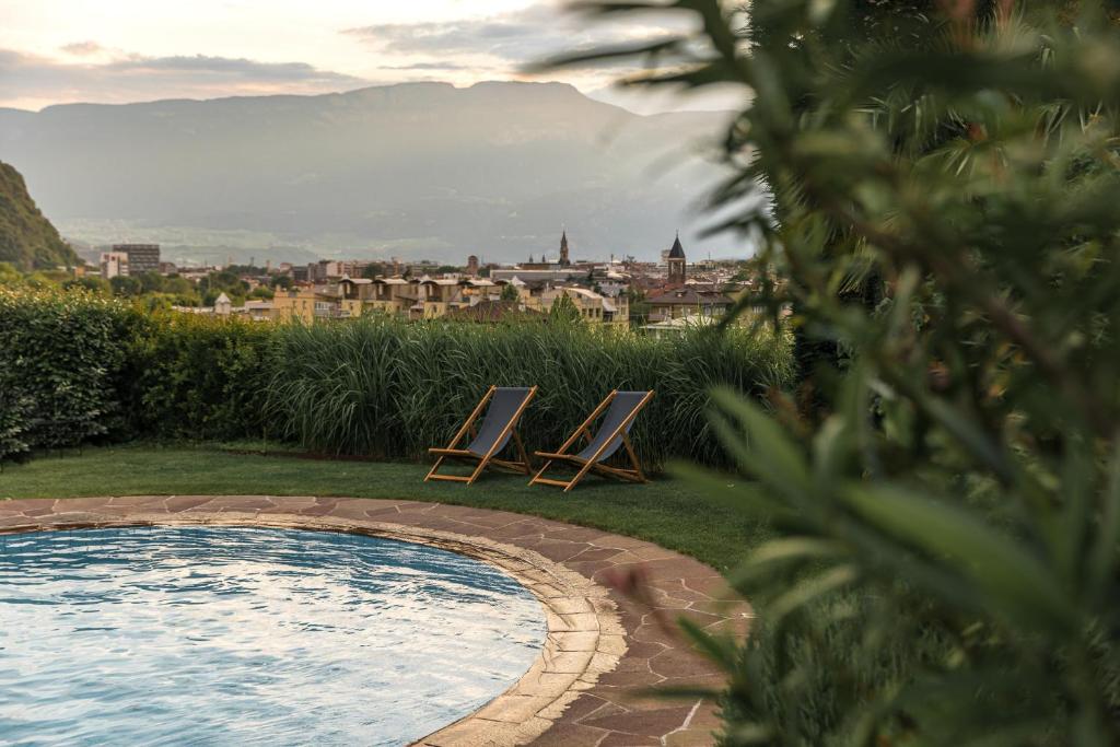 two lounge chairs sitting next to a swimming pool at Hotel Magdalener Hof in Bolzano