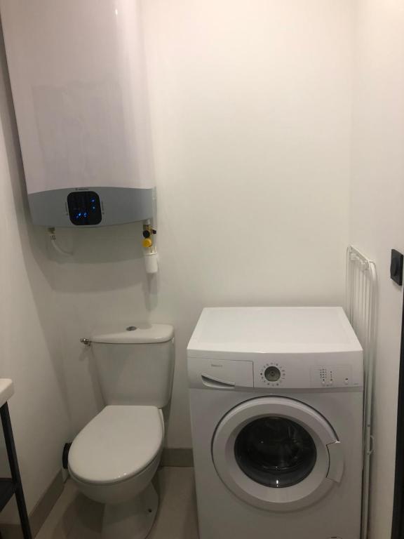 a small bathroom with a toilet and a washing machine at Sublime Sanary plage in Sanary-sur-Mer