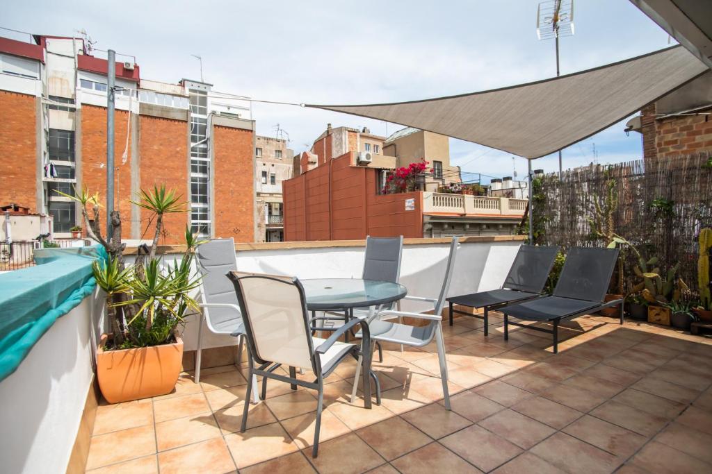 d'une terrasse sur le toit avec une table et des chaises. dans l'établissement 31mai1043 - Sunny home terrace Sagrada Familia, à Barcelone
