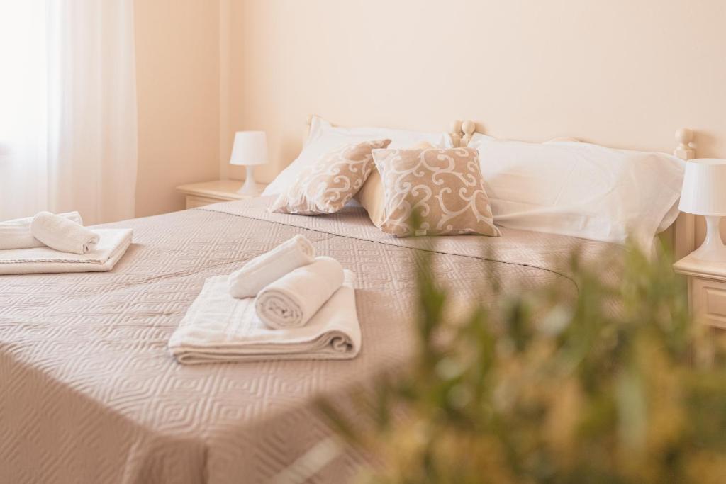 białe łóżko z ręcznikami i poduszkami w obiekcie Ancóramare w mieście Stintino