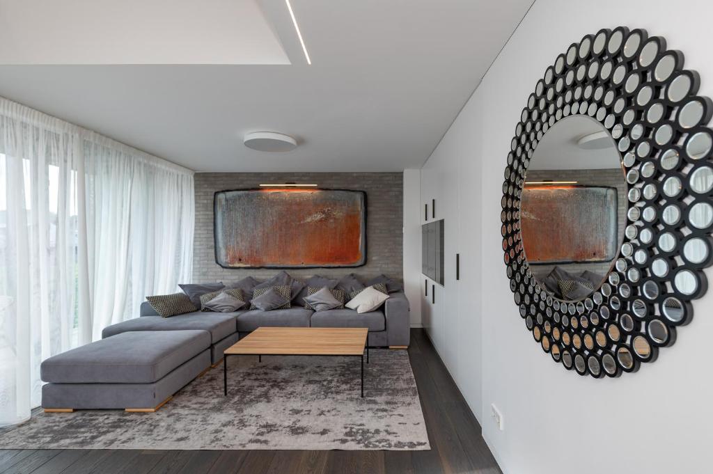 uma sala de estar com um sofá e um espelho em Luxury 2 BD Apartment with terrace by Hostlovers em Kaunas