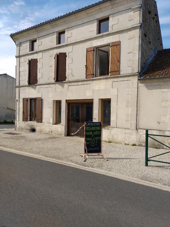 um edifício com um sinal em frente em Chez cococuisine em Les Nouillers