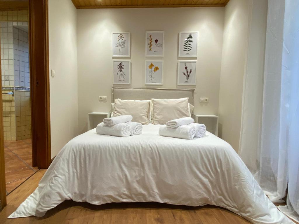 Un dormitorio con una cama blanca con toallas. en Villa Maribel, en Foz