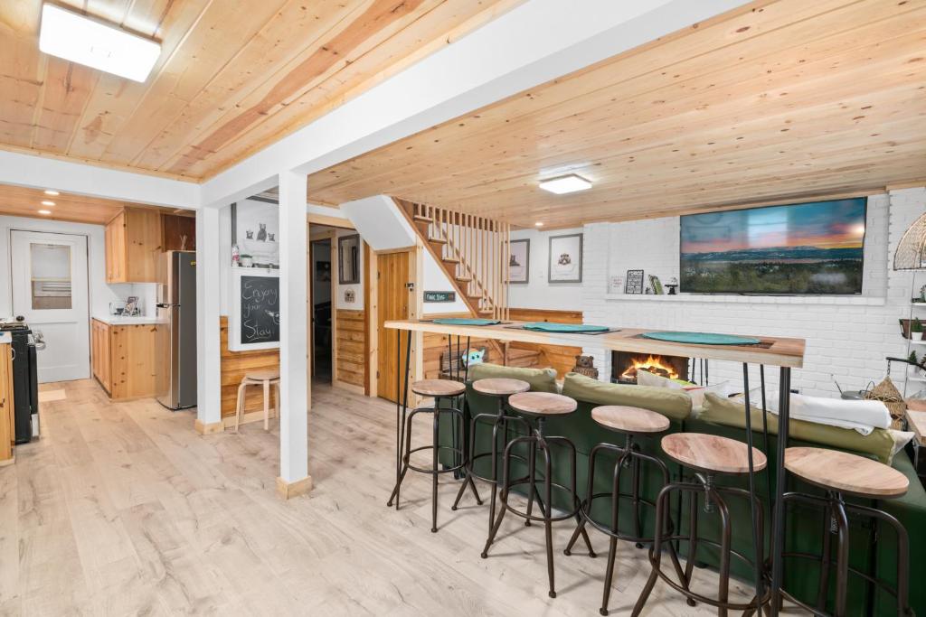 uma cozinha e sala de estar com um bar e bancos em Yoda Maple Cabin- Awesome cabin with great amenities, you can feel the warmth of this charming cabin em Sugarloaf