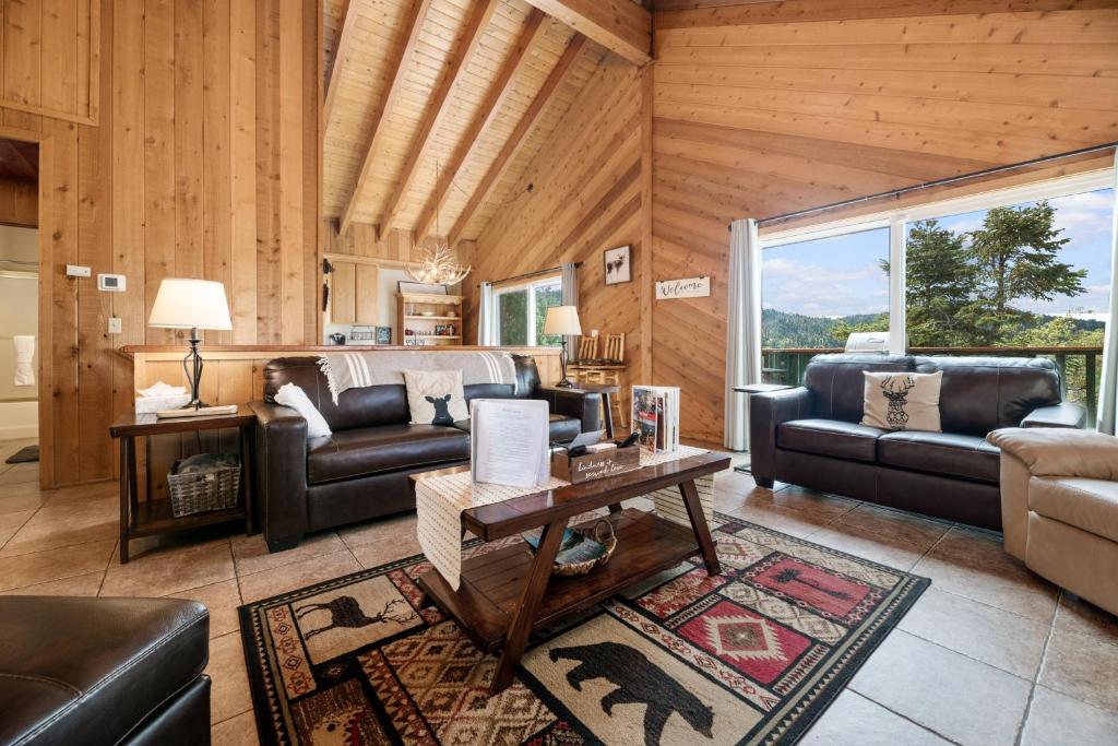 a living room with leather furniture and a large window at Wolf View Lodge - Adorable and modern cabin with well-appointed mountain decor in Big Bear Lake